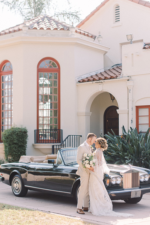  a romantic garden wedding at a Spanish inspired venue with the bride in a lace gown and the groom in a tan suit – couple in the car