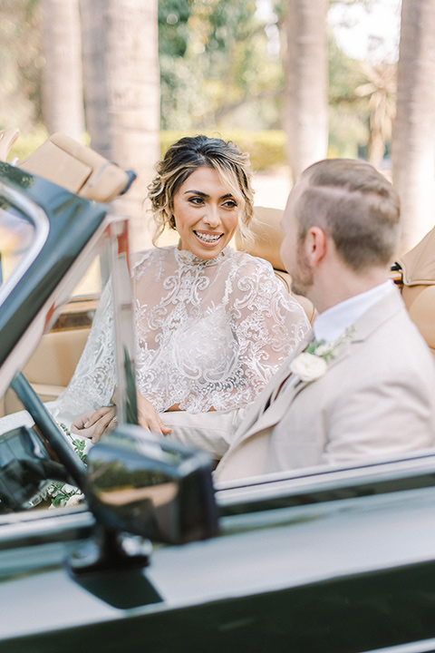  a romantic garden wedding at a Spanish inspired venue with the bride in a lace gown and the groom in a tan suit – couple in the car 