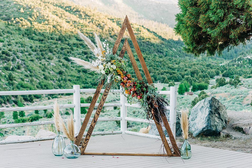  a greenery las vegas wedding at a rustic venue with the bride in an A-line gown and the groom in a green suit – ceremony decor