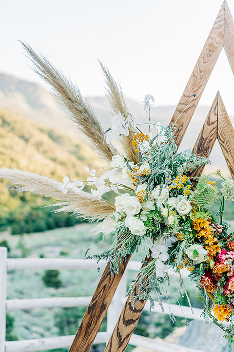  a greenery las vegas wedding at a rustic venue with the bride in an A-line gown and the groom in a green suit – florals