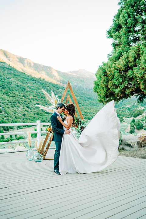  a greenery las vegas wedding at a rustic venue with the bride in an A-line gown and the groom in a green suit – couple kissing