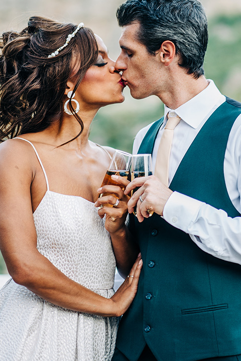  a greenery las vegas wedding at a rustic venue with the bride in an A-line gown and the groom in a green suit – couple embracing