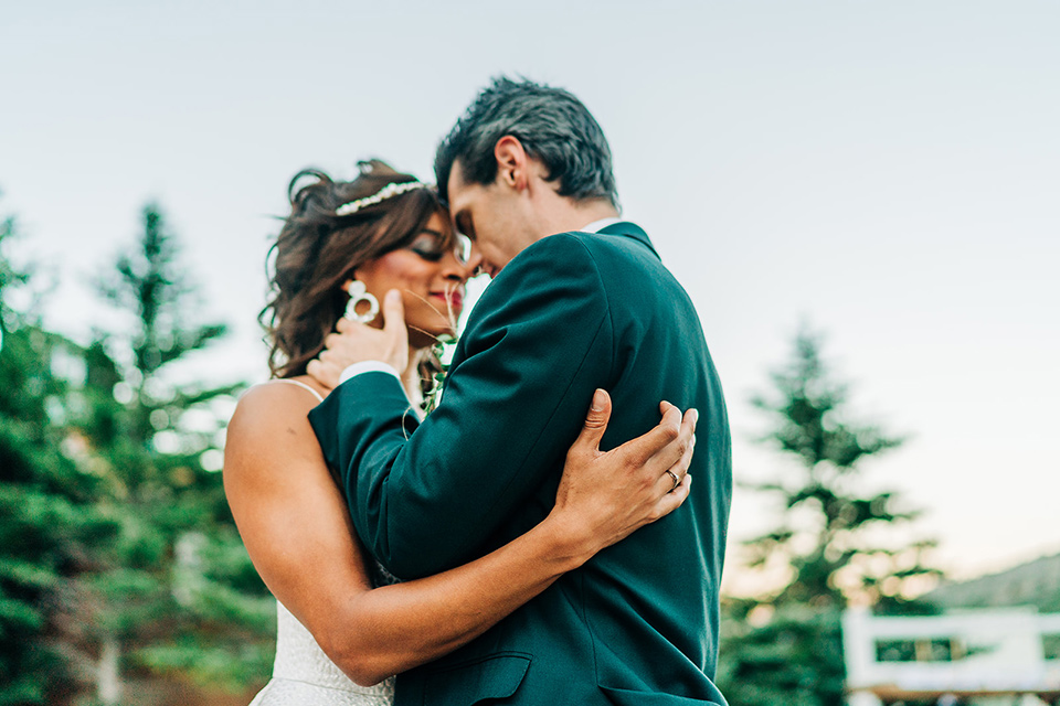  a greenery las vegas wedding at a rustic venue with the bride in an A-line gown and the groom in a green suit – couple hugging