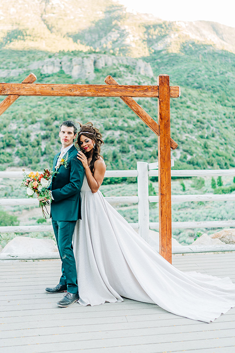  a greenery las vegas wedding at a rustic venue with the bride in an A-line gown and the groom in a green suit – couple with champagne