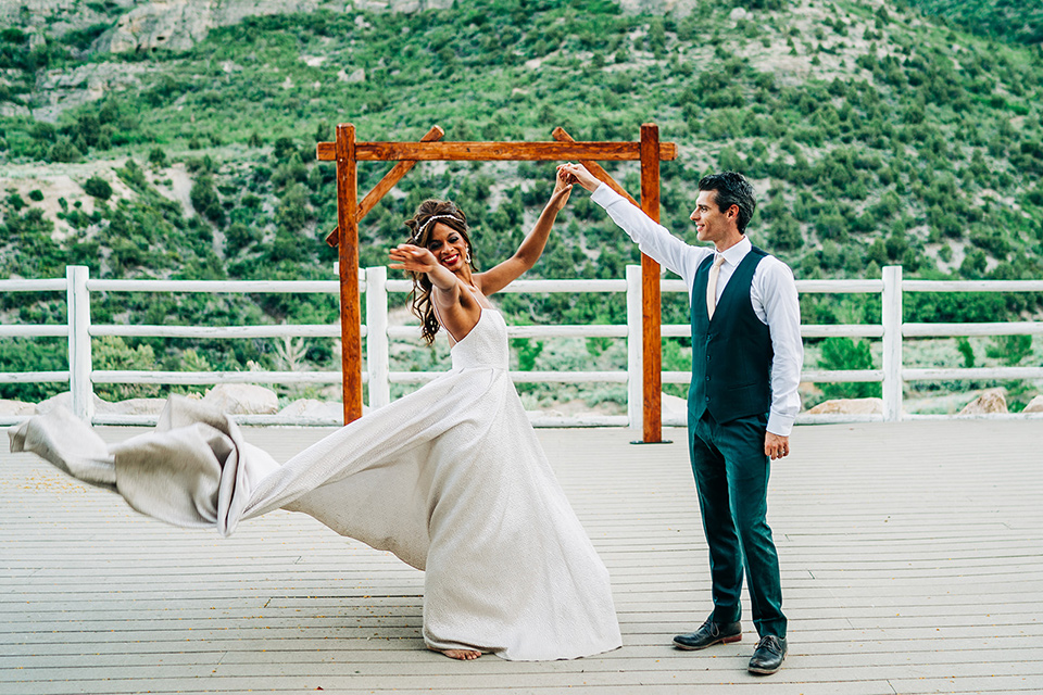  a greenery las vegas wedding at a rustic venue with the bride in an A-line gown and the groom in a green suit – dancing