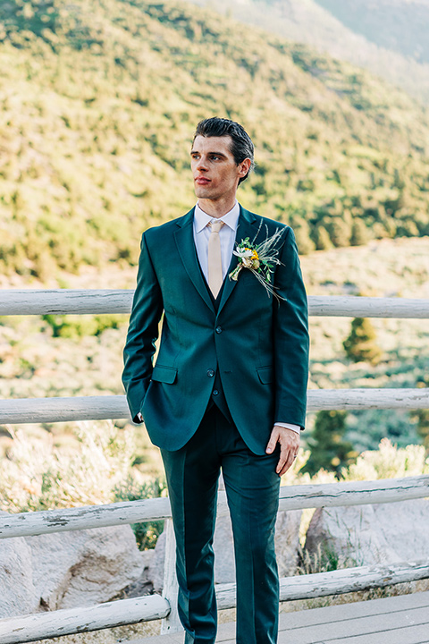  a greenery las vegas wedding at a rustic venue with the bride in an A-line gown and the groom in a green suit – groom