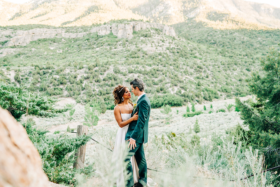  a greenery las vegas wedding at a rustic venue with the bride in an A-line gown and the groom in a green suit – couple touching heads