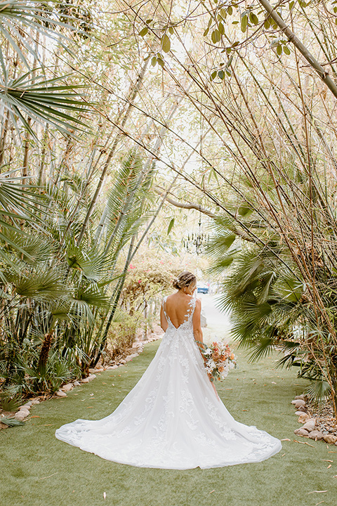  earth-toned boho wedding with the bridesmaids in green dresses, groomsmen in tan suits, and the groom in a caramel suit – bride