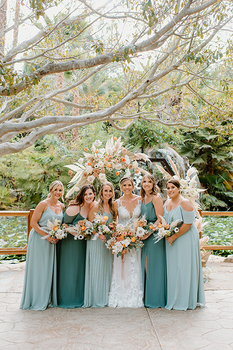  earth-toned boho wedding with the bridesmaids in green dresses, groomsmen in tan suits, and the groom in a caramel suit – bridesmaids 
