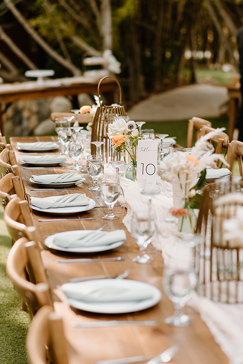  earth-toned boho wedding with the bridesmaids in green dresses, groomsmen in tan suits, and the groom in a caramel suit – table decor 