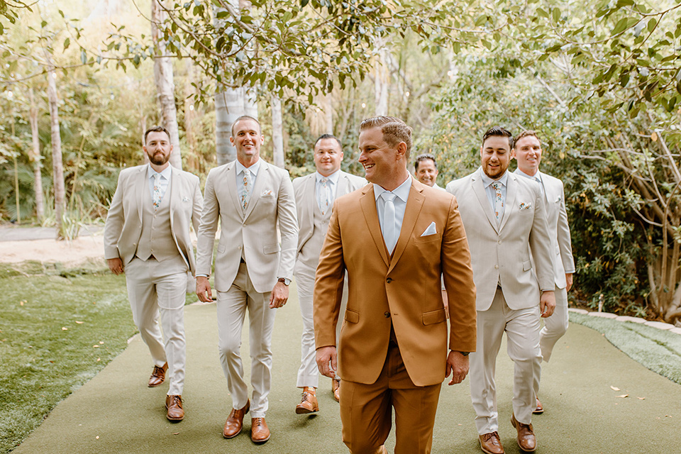  earth-toned boho wedding with the bridesmaids in green dresses, groomsmen in tan suits, and the groom in a caramel suit – groomsmen