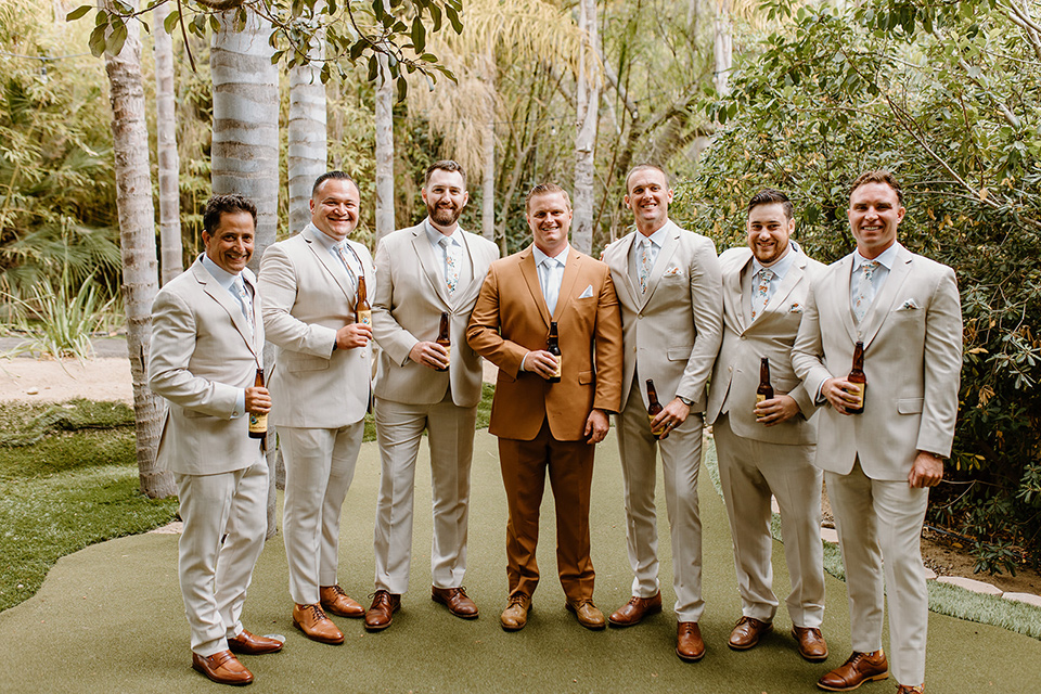  earth-toned boho wedding with the bridesmaids in green dresses, groomsmen in tan suits, and the groom in a caramel suit – groomsmen