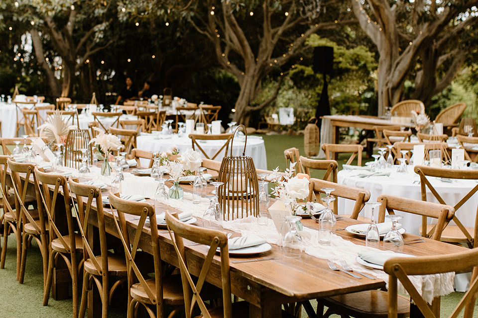  earth-toned boho wedding with the bridesmaids in green dresses, groomsmen in tan suits, and the groom in a caramel suit – tables
