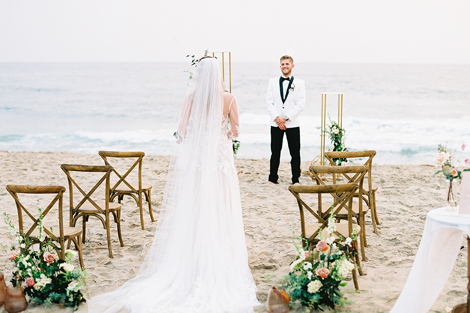  beach side wedding with the bride in a flowing lace gown and the groom in a white tuxedo – ceremony 