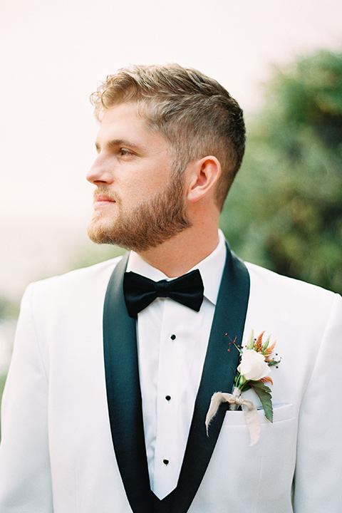  beach side wedding with the bride in a flowing lace gown and the groom in a white tuxedo – groom