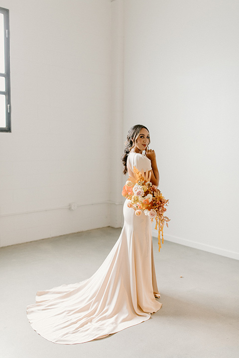  an amber toned wedding in san diego california with the bride in a modern fitted gown with cap sleeves and the groom in a caramel suit – bride in her gown 