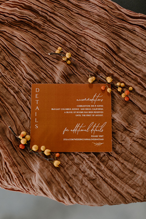  an amber toned wedding in san diego california with the bride in a modern fitted gown with cap sleeves and the groom in a caramel suit – invitations 