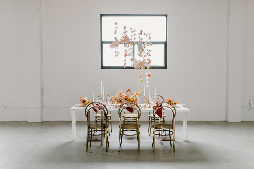  an amber toned wedding in san diego california with the bride in a modern fitted gown with cap sleeves and the groom in a caramel suit – reception tables