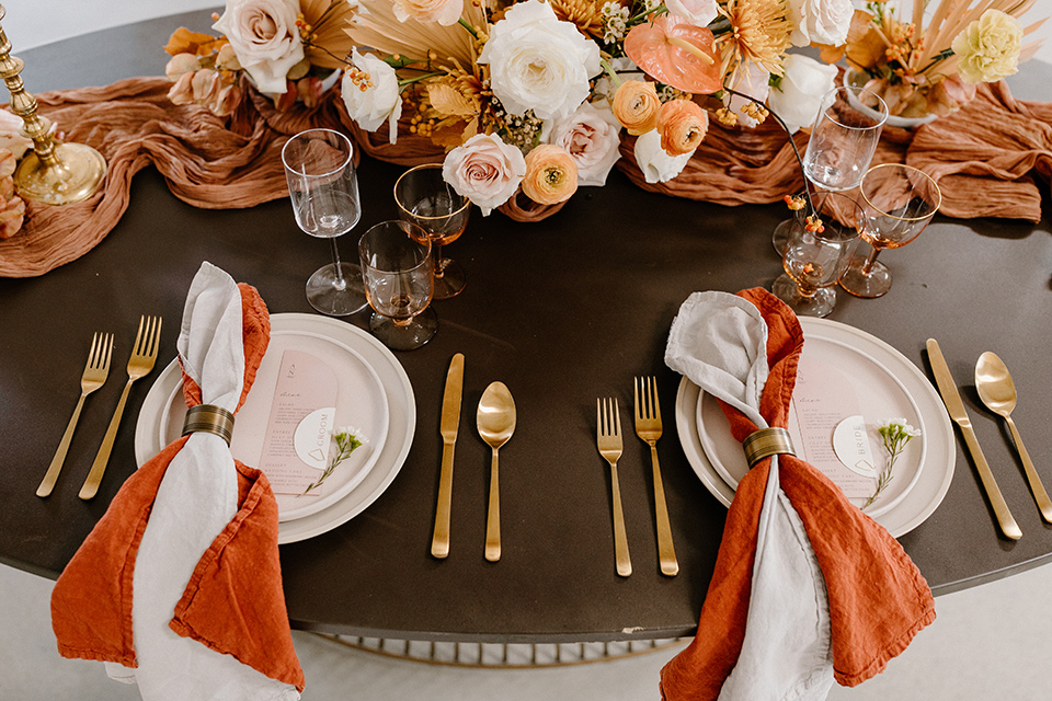  an amber toned wedding in san diego california with the bride in a modern fitted gown with cap sleeves and the groom in a caramel suit – reception tables and décor