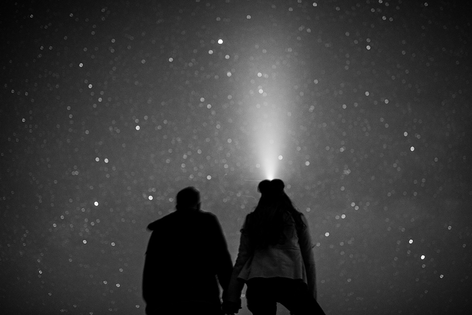  wildflower wedding in a field with the bride in a flowing gown and bridal wings, and the groom in a tan suit and bolo tie – looking at the sky at night