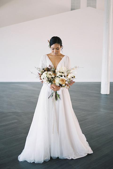  minimalistic nude wedding with vintage touches, the bride in a flowing gown with sleeves and the groom in a tan suit - bride