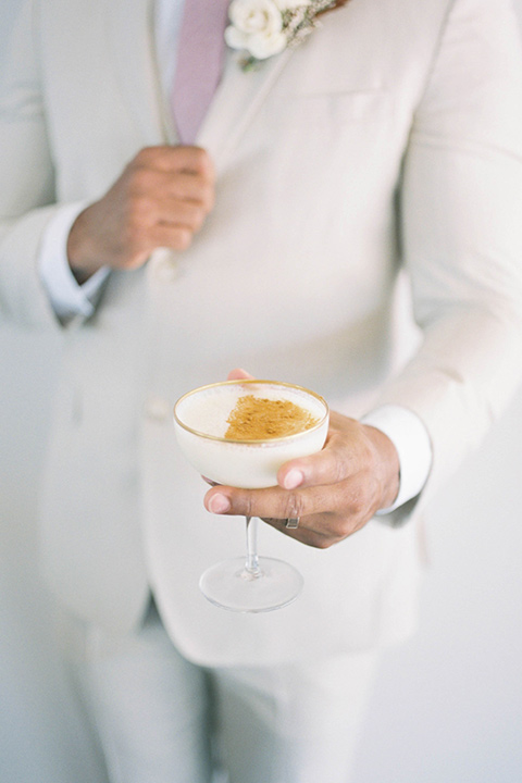  minimalistic nude wedding with vintage touches, the bride in a flowing gown with sleeves and the groom in a tan suit – cheersing 