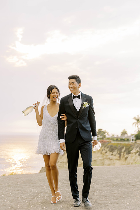  modern black and white upscale wedding on the cliffs overlooking the ocean –  couple with champagne 