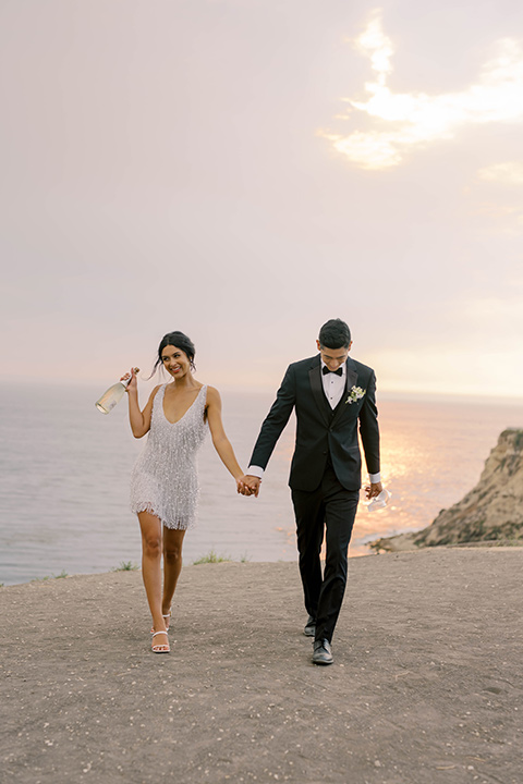  modern black and white upscale wedding on the cliffs overlooking the ocean –  couple with champagne 