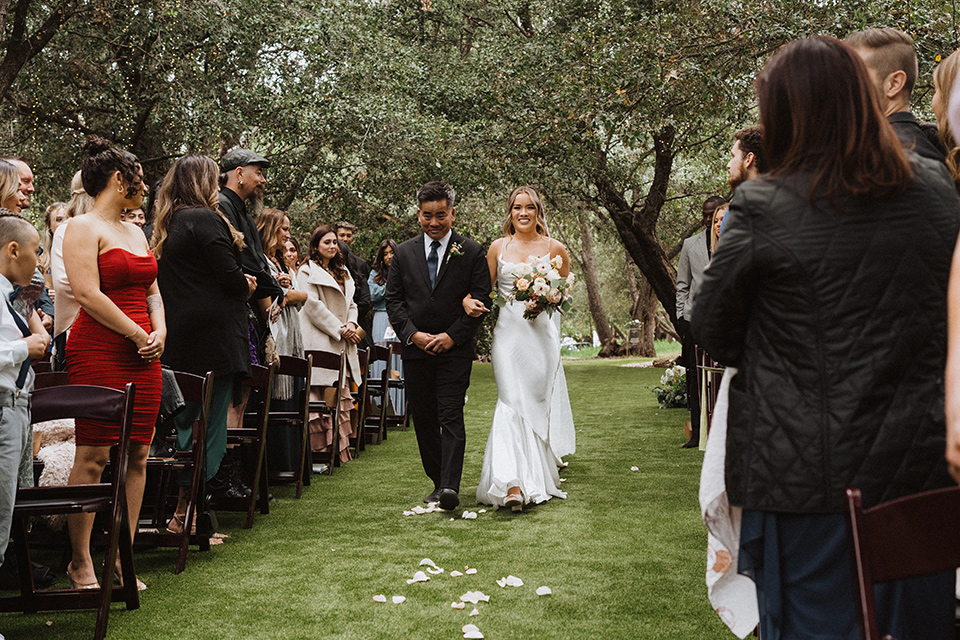  a neutral monochromatic earth toned wedding with boho trendy vibes - bride walking down the aisle 