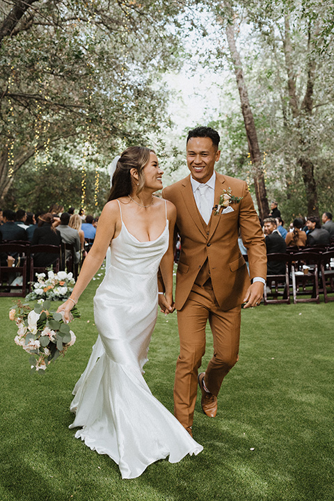  a neutral monochromatic earth toned wedding with boho trendy vibes - walking down the aisle 