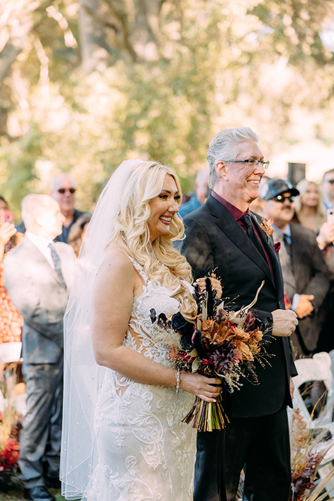  a moody western wedding with burgundy and orange colors - bride and father at ceremony 