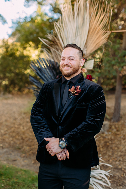  a moody western wedding with burgundy and orange colors - groom at ceremony 