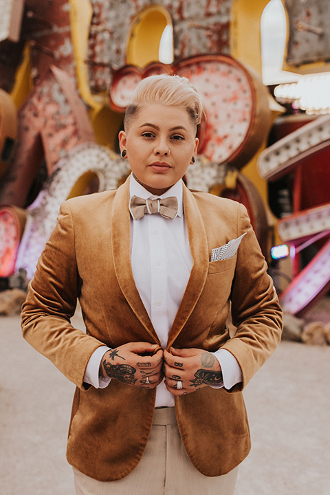 same sex wedding with two brides at the neon museum in las vegas with one brief is a bohemian ballgown and the other in a gold velvet tuxedo coat and tan pants – bride in gold velvet tuxedo and tan pants 