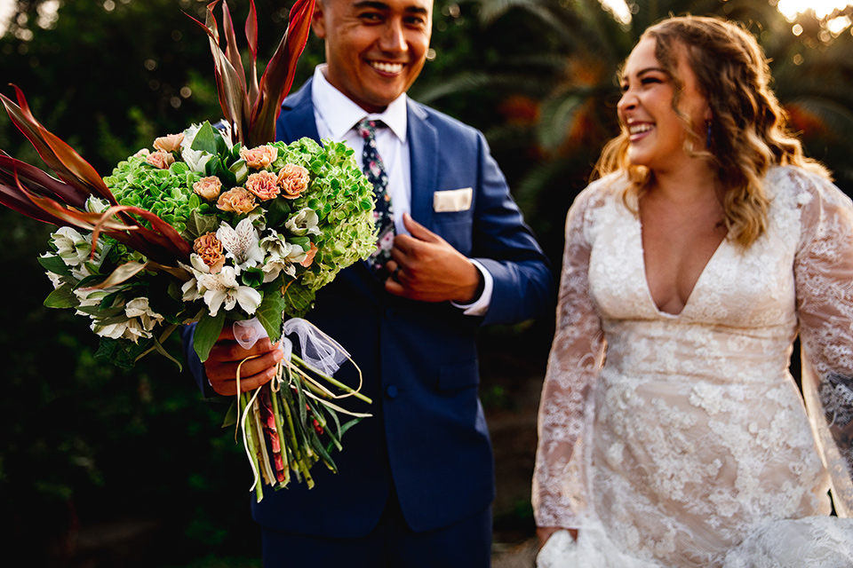  newport wedding in the cliffs with the bride in a lace gown and the groom in a navy blue suit – couple laughing 
