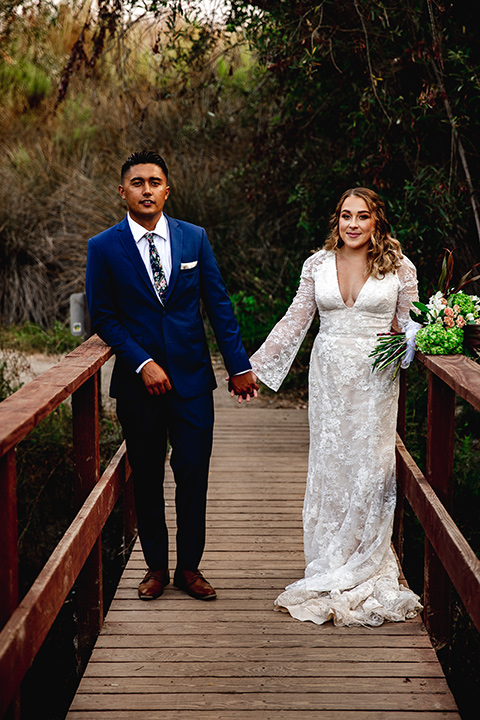 newport wedding in the cliffs with the bride in a lace gown and the groom in a navy blue suit – couple on the bridge