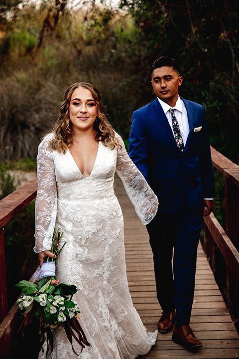  newport wedding in the cliffs with the bride in a lace gown and the groom in a navy blue suit – couple on the bridge 