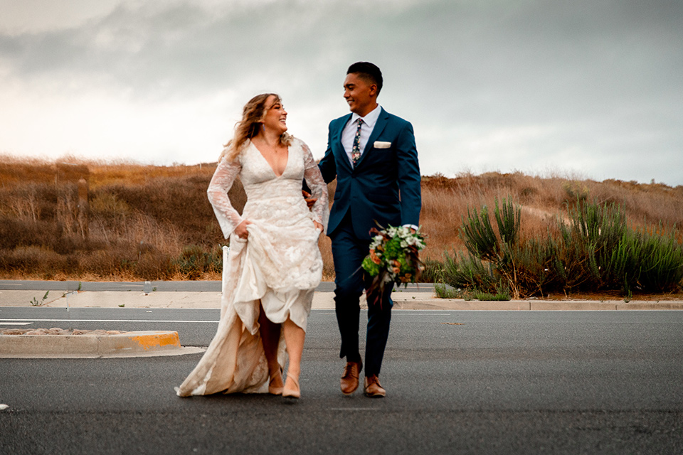  newport wedding in the cliffs with the bride in a lace gown and the groom in a navy blue suit – crossing the street 