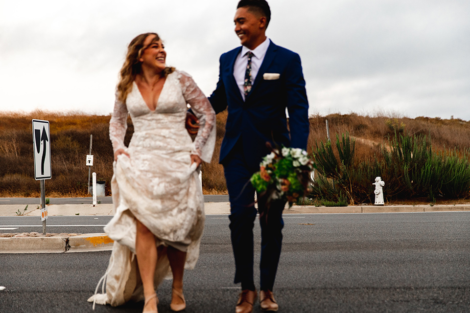  newport wedding in the cliffs with the bride in a lace gown and the groom in a navy blue suit – crossing the street 