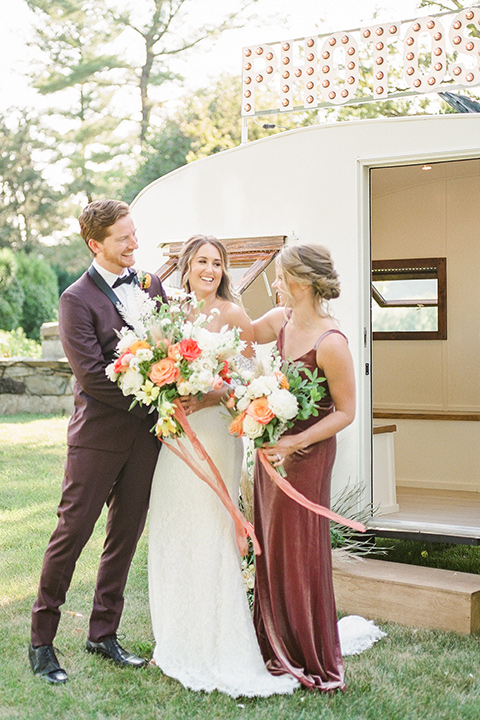  blush and burgundy wedding in the woods with the bride in a boho lace gown, the groom in a burgundy shawl tuxedo, and the bridesmaids in a dusty blush velvet gown – bridalparty