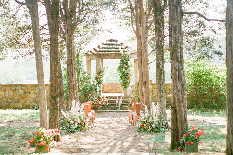  blush and burgundy wedding in the woods with the bride in a boho lace gown, the groom in a burgundy shawl tuxedo, and the bridesmaids in a dusty blush velvet gown – ceremony decor