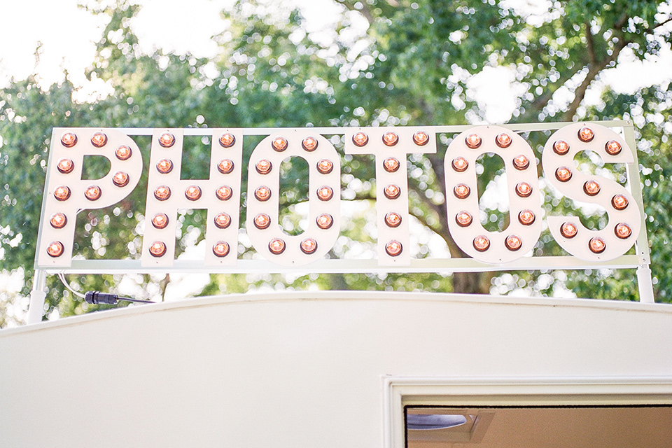  blush and burgundy wedding in the woods with the bride in a boho lace gown, the groom in a burgundy shawl tuxedo, and the bridesmaids in a dusty blush velvet gown – photo booth