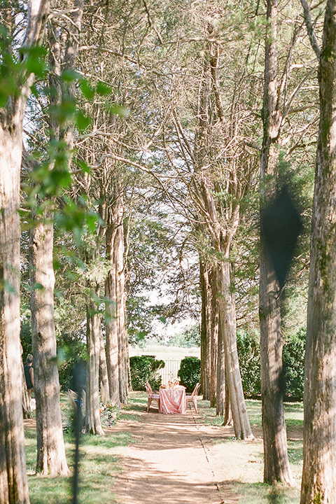  blush and burgundy wedding in the woods with the bride in a boho lace gown, the groom in a burgundy shawl tuxedo, and the bridesmaids in a dusty blush velvet gown – table