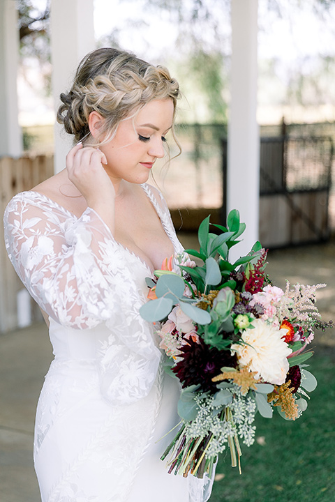  a lavender and black wedding in a garden – with the bride in a long sleeve lace gown and the groom in a black tuxedo – bride in her gown 