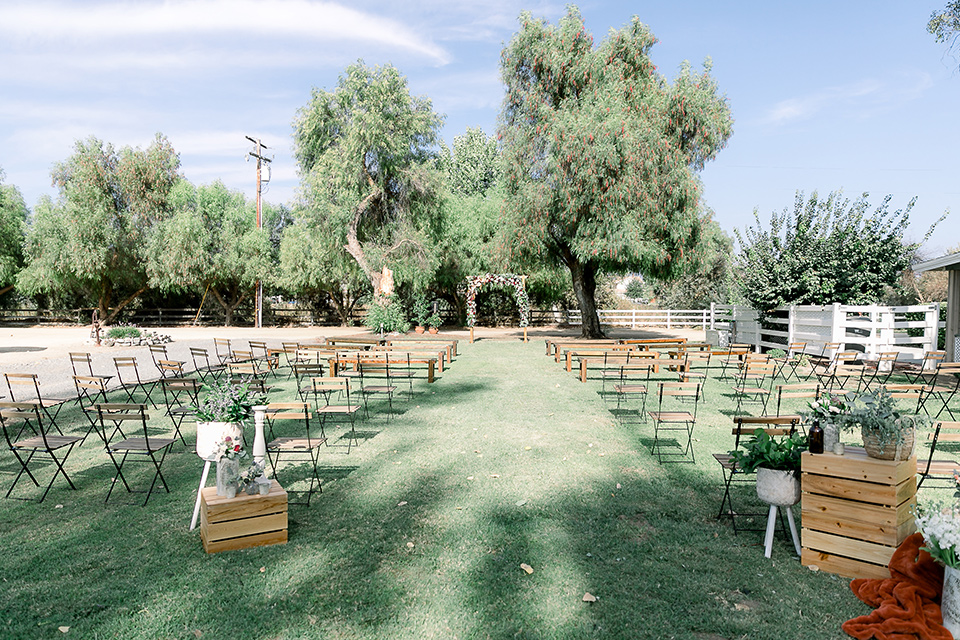  a lavender and black wedding in a garden – with the bride in a long sleeve lace gown and the groom in a black tuxedo – ceremony space