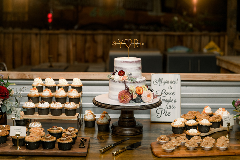  a lavender and black wedding in a garden – with the bride in a long sleeve lace gown and the groom in a black tuxedo – dessert table