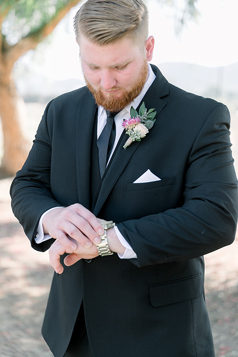  a lavender and black wedding in a garden – with the bride in a long sleeve lace gown and the groom in a black tuxedo – groom