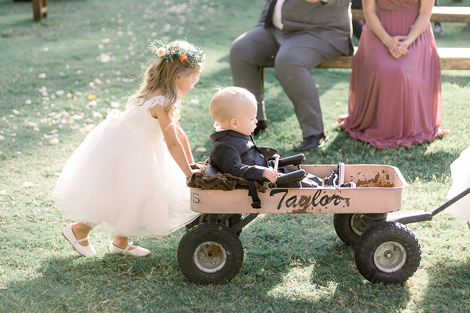  a lavender and black wedding in a garden – with the bride in a long sleeve lace gown and the groom in a black tuxedo – ring bearer and flower girl