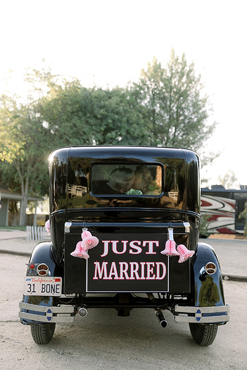  a lavender and black wedding in a garden – with the bride in a long sleeve lace gown and the groom in a black tuxedo – get away vintage car 