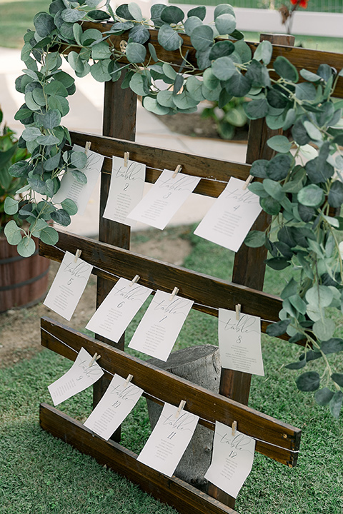  a lavender and black wedding in a garden – with the bride in a long sleeve lace gown and the groom in a black tuxedo – seating chart