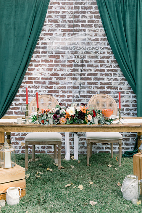  a lavender and black wedding in a garden – with the bride in a long sleeve lace gown and the groom in a black tuxedo – sweetheart table 